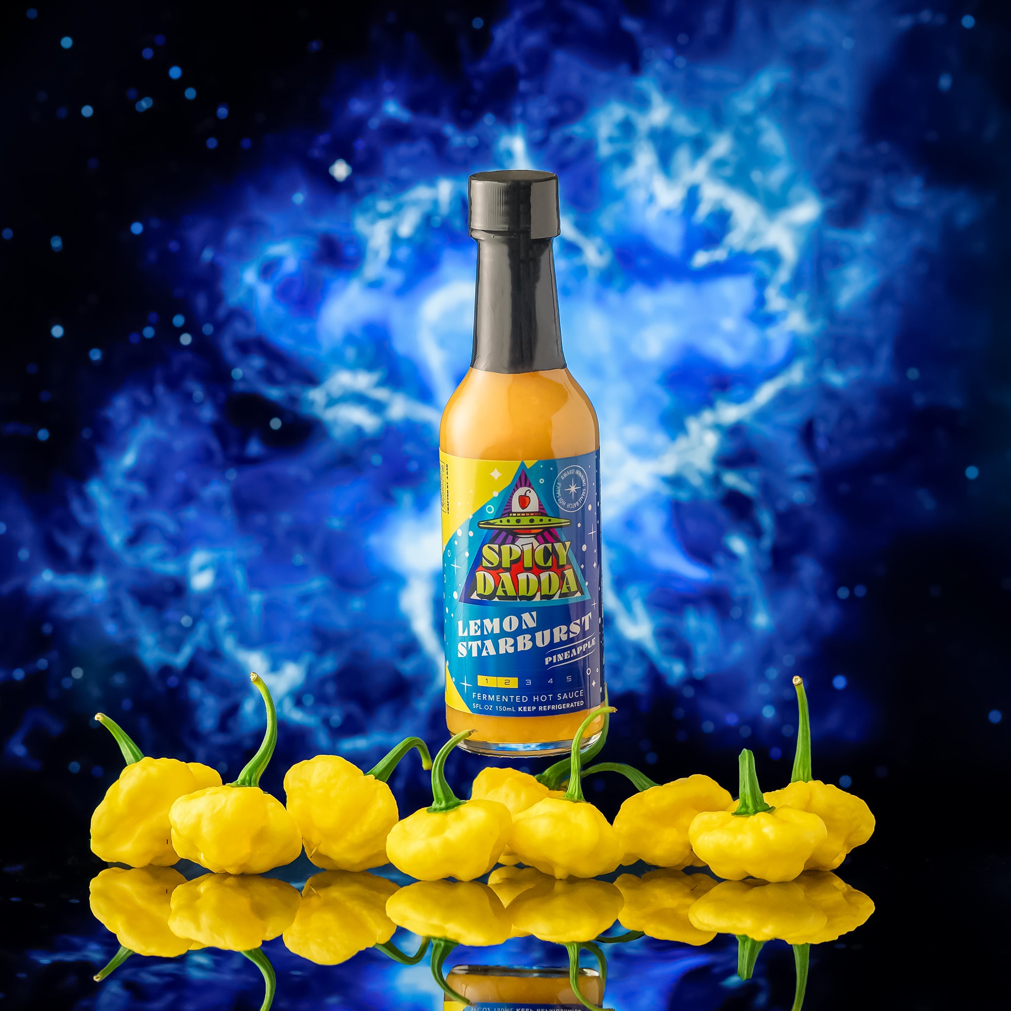 Spicy Dadda Lemon Starburst small batch fermented hot sauce bottle surrounded by homegrown lemon starburst superhot peppers against a surreal cosmic blue background.