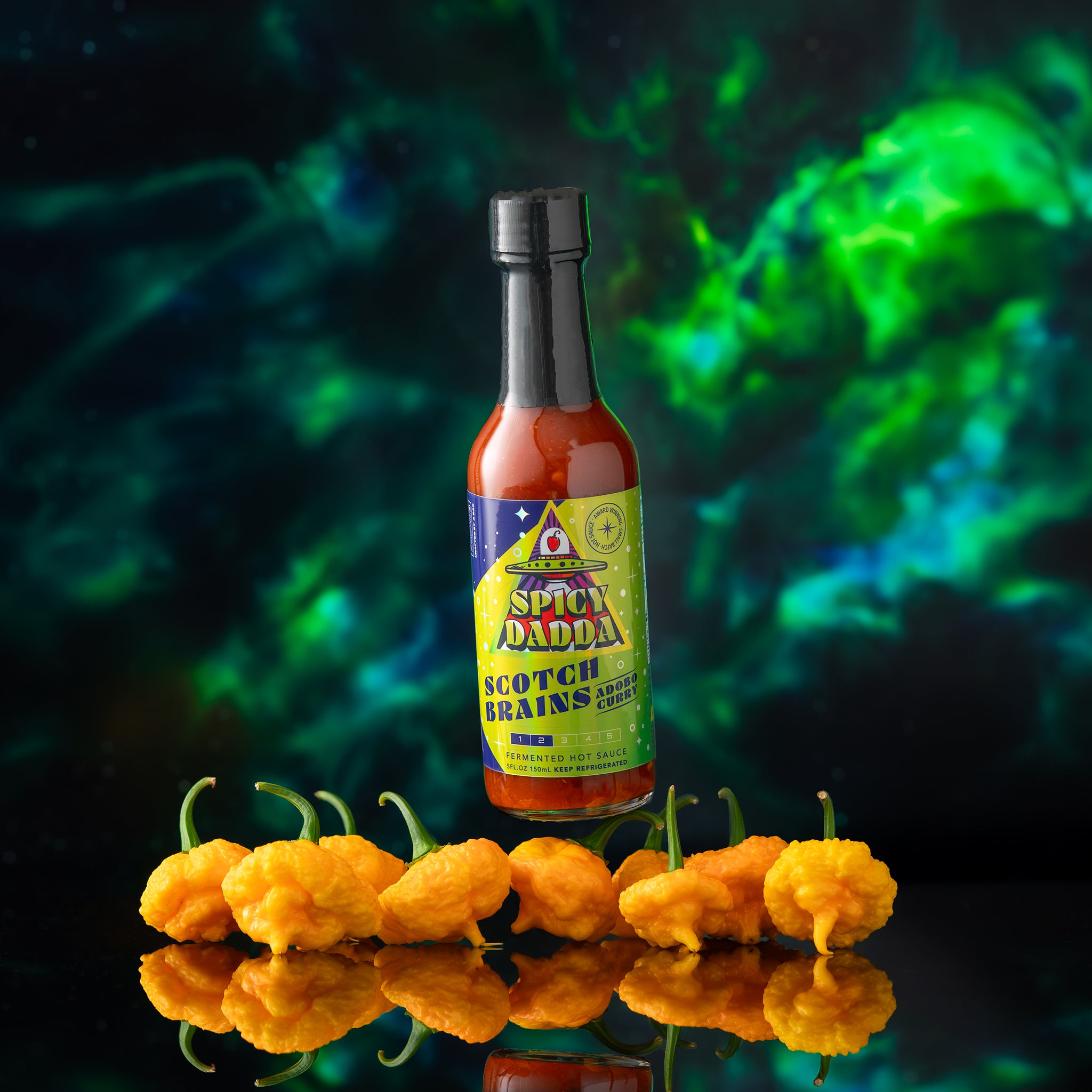 Spicy Dadda Scotch Brains Adobo Curry fermented hot sauce bottle surrounded by fresh homegrown superhot peppers against a surreal cosmic background.